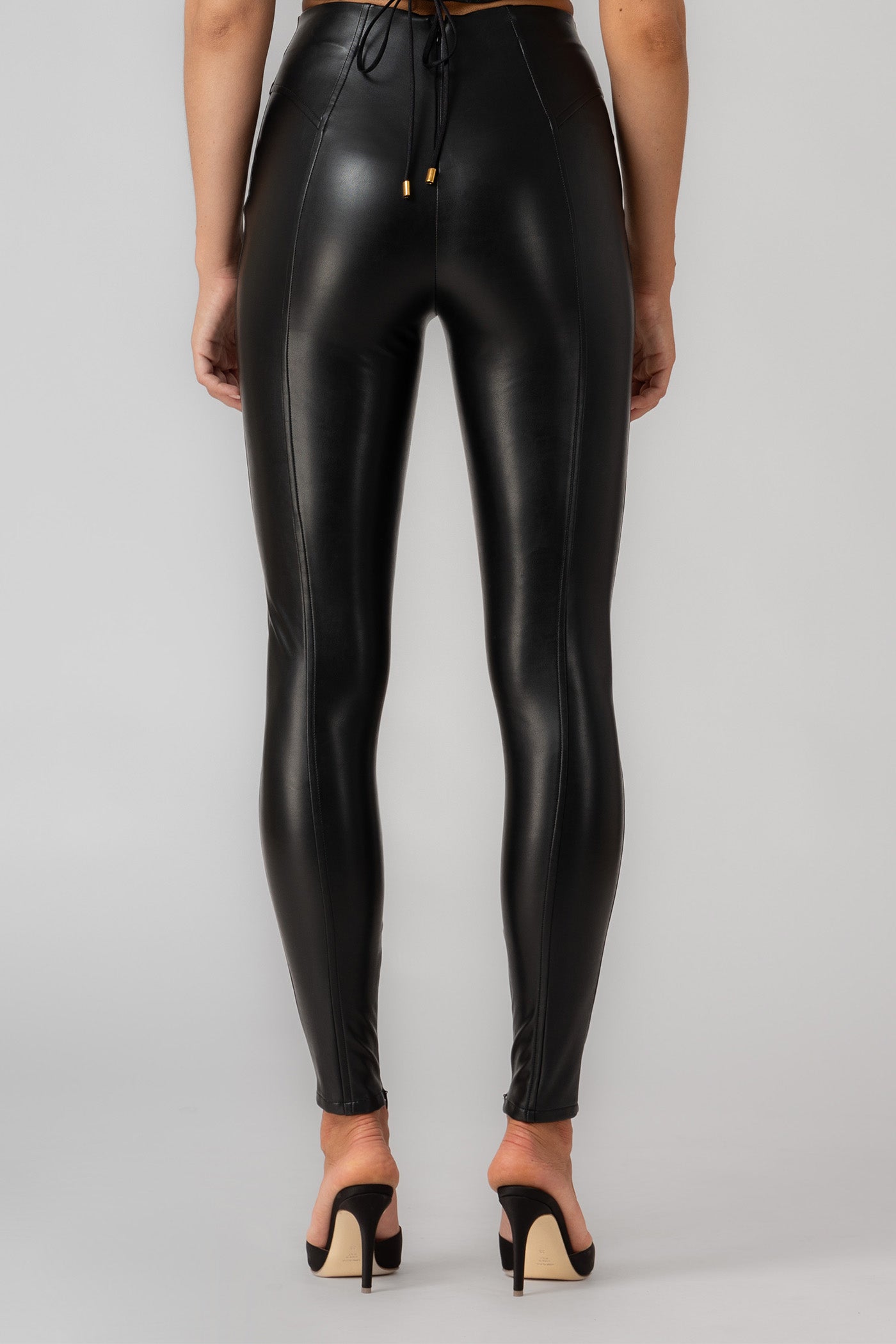 Black premium eco leather leggings with corset inspired decorative stitching metallic zipper fastening at the back and hidden zippers at the ankles. Murmur